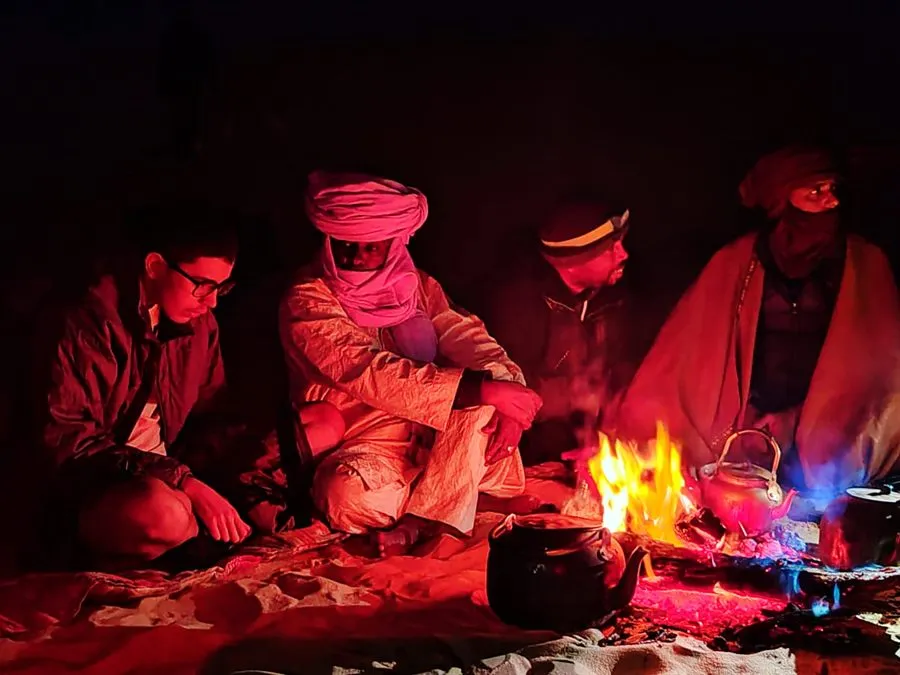 Moment partagé autour du feu pendant un bivouac dans le Sahara